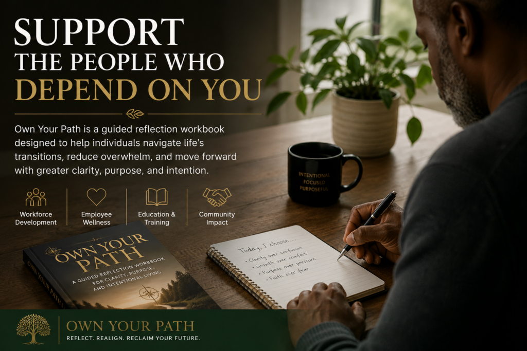 A professional sits at a desk writing in a journal beside the Own Your Path reflection workbook, illustrating employee wellness, workforce development, and personal growth for organizations.